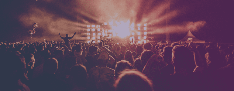 A crowd of people in front of lights at night.